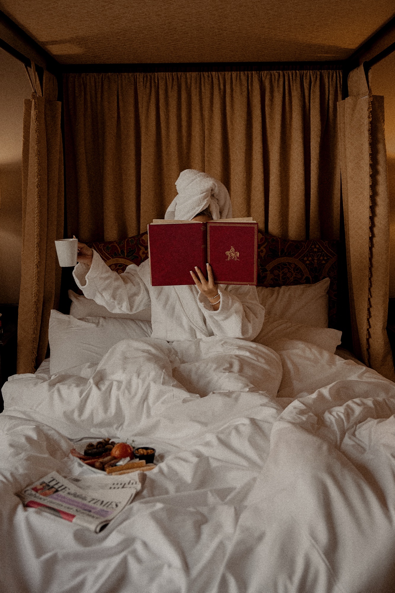 A cup of coffee and an open book on a table beside a window at The Red Lion, soft morning light across the setting.