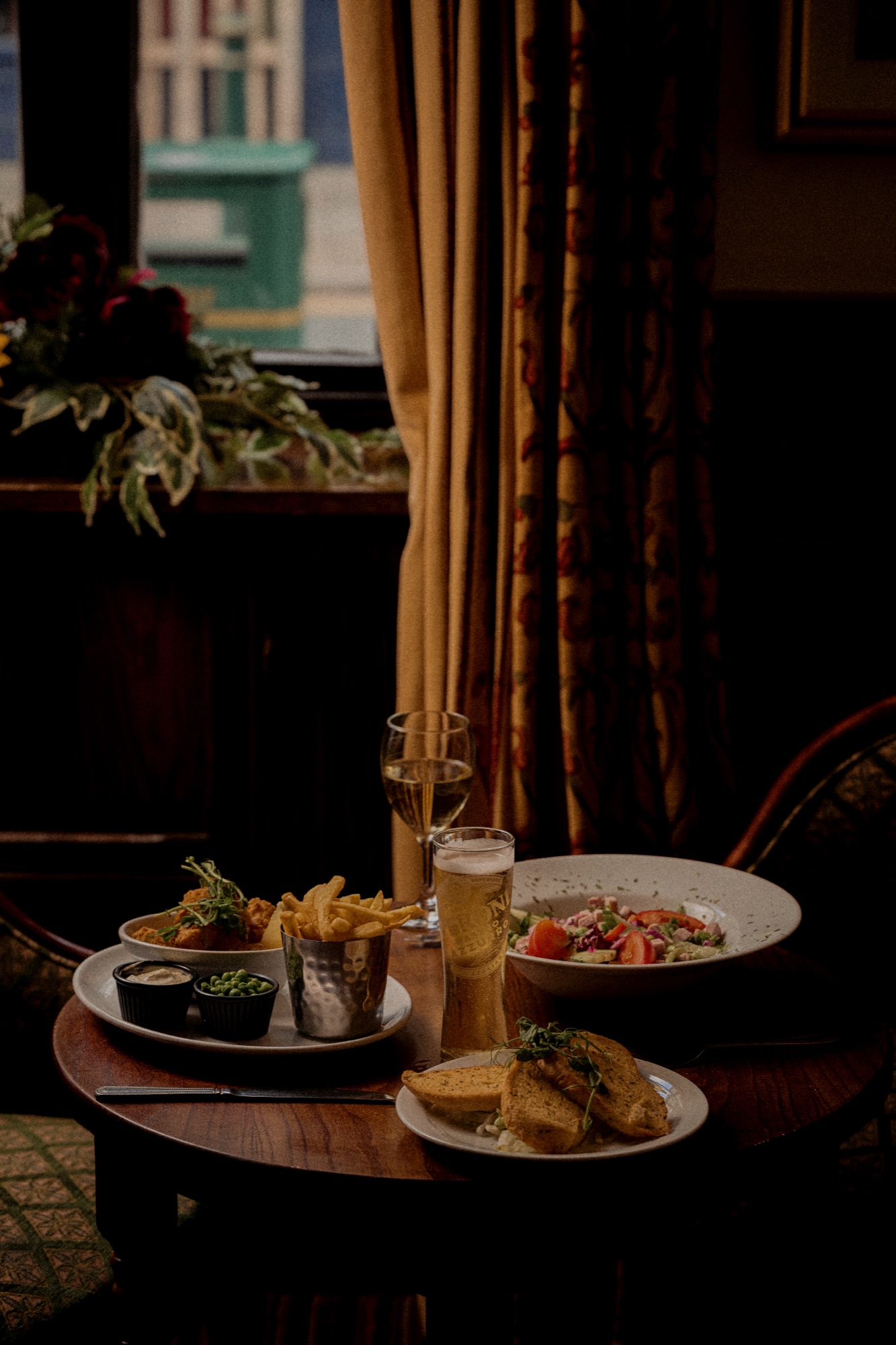A laid dining table at The Red Lion with glassware, linen and warm interior tones.