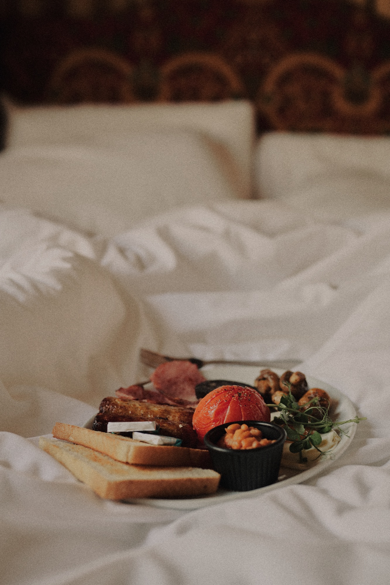A breakfast plate served on a bed with white linen at The Red Lion.