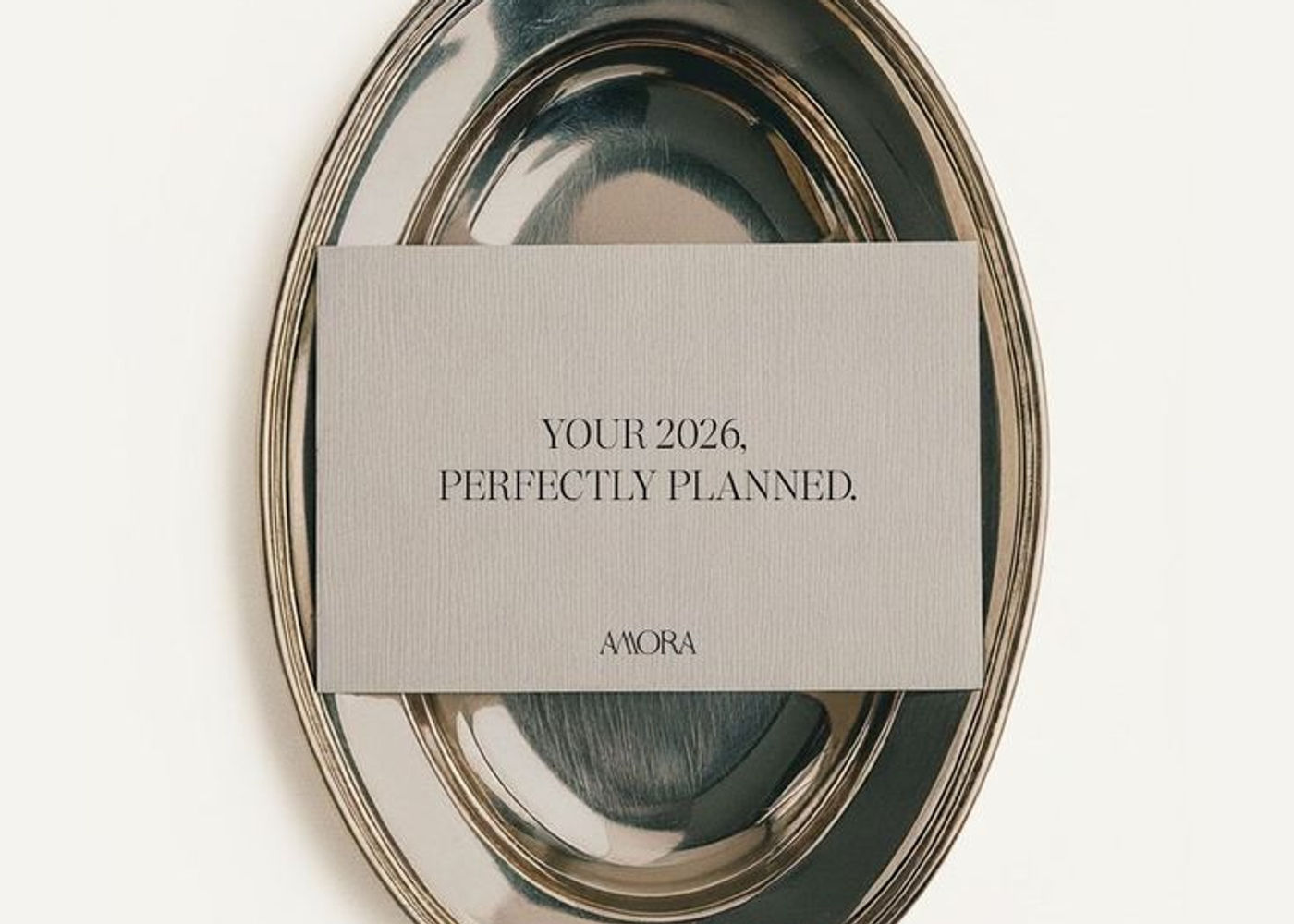 Minimalist luxury flat lay featuring a silver tray with a refined card reading “Your 2026, perfectly planned,” styled in a neutral, editorial aesthetic.