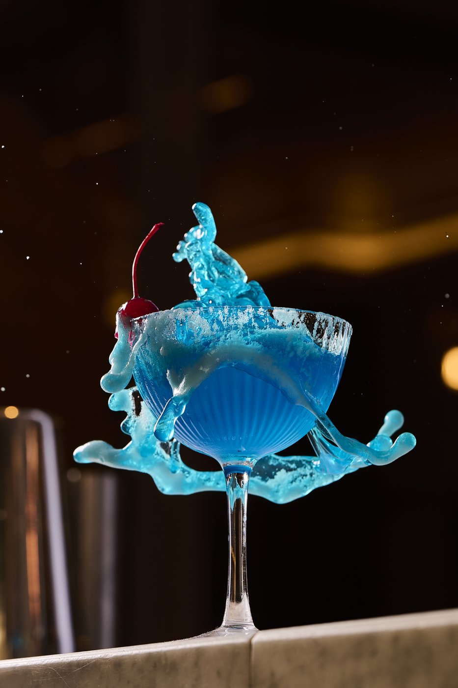 A vivid blue cocktail caught mid-splash at the O.W. bar, a moment of movement and theatre.